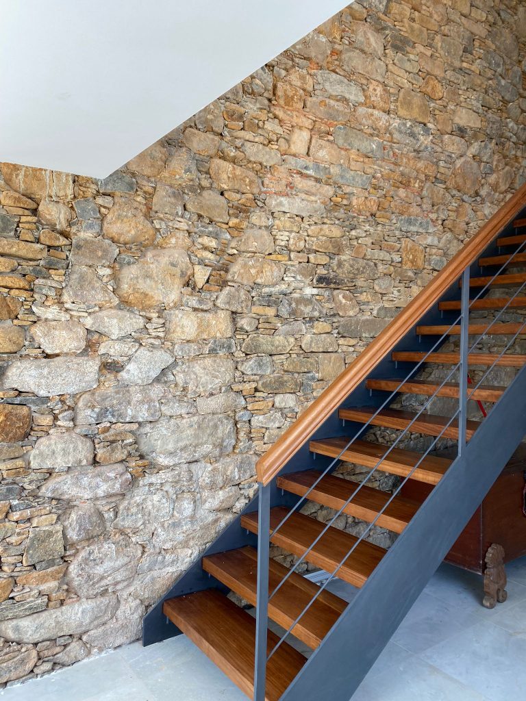 Escaleras acceso planta superior con pared de Piedra en Casa La Neja